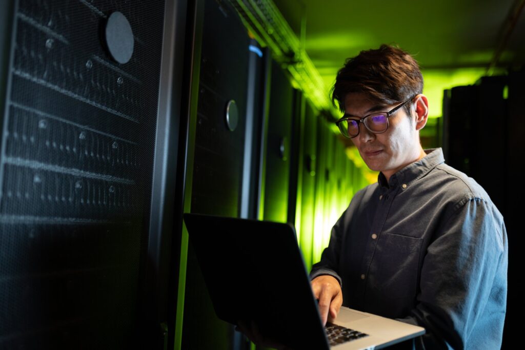 IT engineer using a laptop in a data center